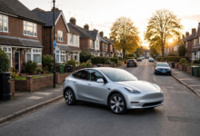 Silver Tesla Model Y electric SUV parked on a British suburban street at golden hour