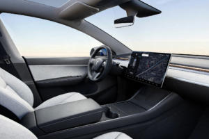 Minimalist Tesla Model Y interior with large central touchscreen and cloth seats